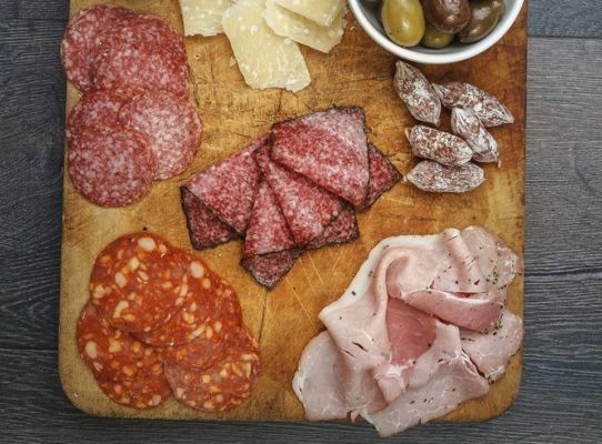 Cutting board of sliced meat and smoked cheese